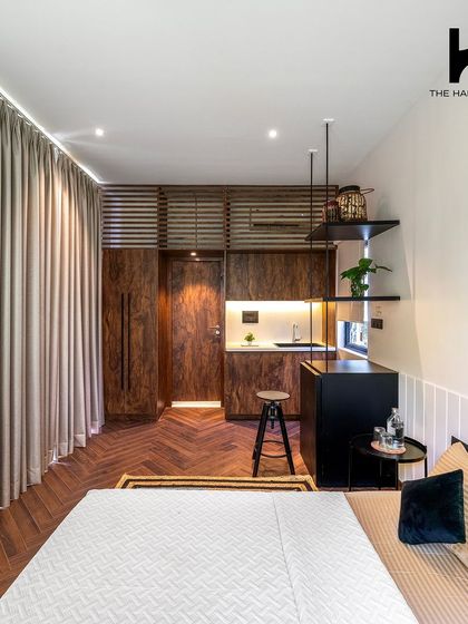 This 240 sq. ft. prefab pod features luxury interiors with rich wood tones and herringbone flooring. The design cleverly integrates a kitchenette, sleeping area, and storage into a compact and elegant space.