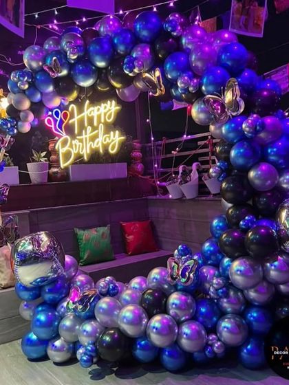 A still image of the beautiful blue and silver butterfly-themed balloon ring against the night sky on a terrace.