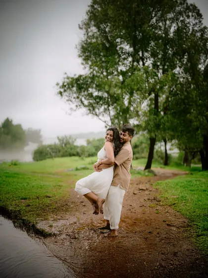 A playful lift in the rain-soaked earth. These are the unscripted, joyful moments that make a pre-wedding shoot so special, capturing pure, unfiltered happiness.