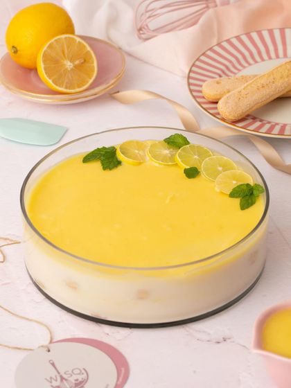 The full Lemon Tiramisu, garnished with fresh lemon slices and mint. It's a bright and zesty dessert, perfect for a sunny day.