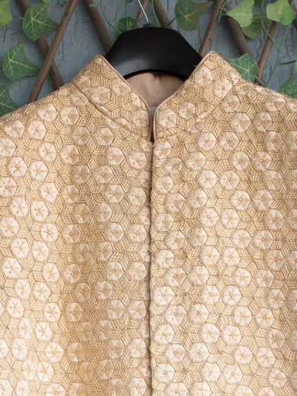 A sneak peek at the intricate, hand-embroidered pattern on Ujjwal's wedding sherwani. The geometric design in a subtle cream tone is a true work of art.