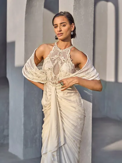 This ivory masterpiece combines the delicacy of embellished mesh with the bold drama of structured sleeves and a fluid, draped bottom. A symphony of couture craftsmanship.