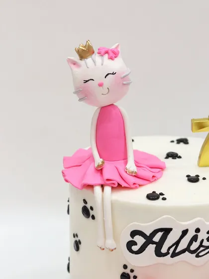 A close-up of the adorable, hand-sculpted kitty ballerina topper with a tiny gold crown.