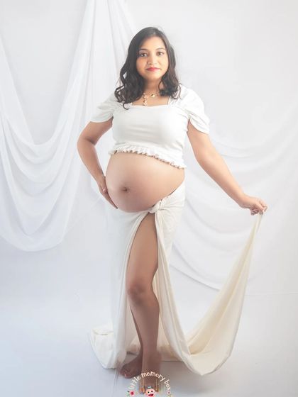 A full-length view of this all-white outfit, showing how the fabric drapes beautifully. It's a simple yet stunning look that highlights the pregnancy glow.