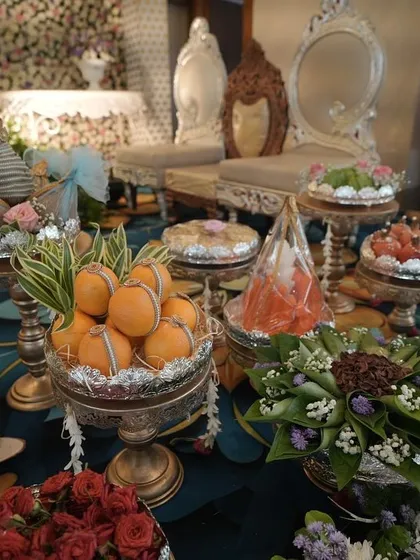 Another angle of the elaborate display of traditional offerings, presented on ornate stands and surrounded by fresh flowers.