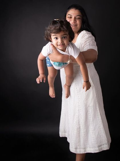 The pure joy of being a mom! This playful shot of a mother lifting her daughter captures a moment of pure happiness and connection. These candid interactions make for the best memories.