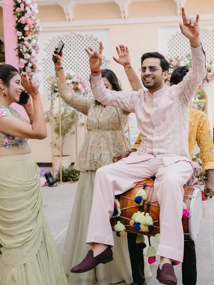 It's not just about the outfits, it's about the vibe. Here's groom Shivam, looking effortlessly stylish and having the time of his life at his Welcome Lunch in a custom pastel embroidered jacket and pants.