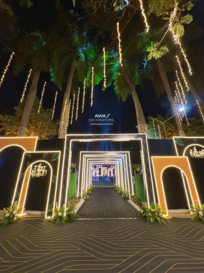 A stunning view of the Sangeet entrance at night, with palm trees and hanging lights adding to the glamorous, tropical vibe.