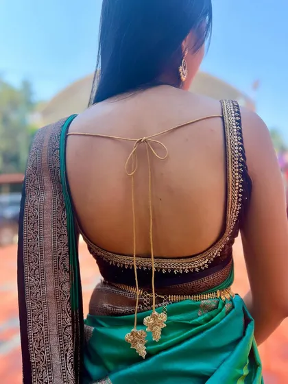 The full back view of the strappy velvet blouse, showing how it creates a modern yet elegant silhouette with a traditional saree.