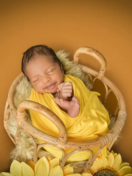 A sleepy smile from a newborn is pure gold. This little one, wrapped in sunny yellow and surrounded by sunflowers, shows how I combine color and props to create a cheerful yet peaceful atmosphere for your baby's first portraits.