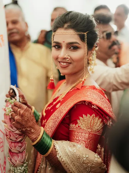 A perfect portrait of a Maharashtrian bride, showcasing the traditional 'mundavalya' and her glowing makeup.