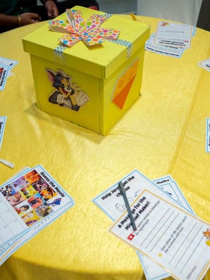 A table set up with themed activity sheets and a collection box for birthday messages.