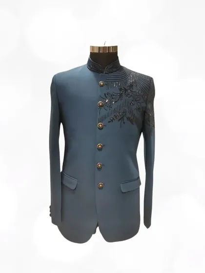 This teal blue Jodhpuri suit features striking black sequin work on the shoulder, offering a modern and edgy take on a classic silhouette.
