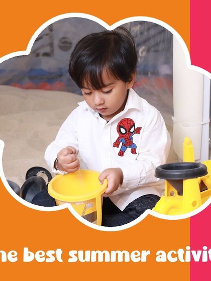 The best summer activity is indoor fun! A toddler enjoys the sand pit, a perfect way to have a beach day without the heat.
