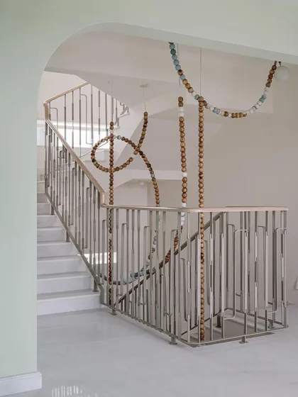 The clean lines of the staircase and railing at Eden House provide the perfect canvas for the organic, flowing form of the LUNA light installation. It's a beautiful example of balance in design.