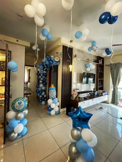 Even a small space can be transformed for a beautiful celebration. Here is an intimate 'Welcome Home' decoration for a baby boy, using balloon pillars, ceiling balloons, and themed banners to make the moment special.