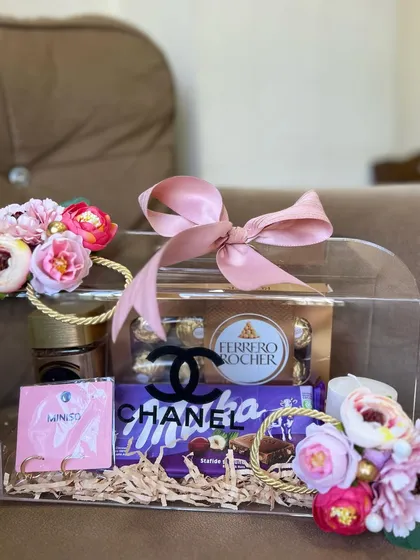 This view shows the hamper ready to be gifted, with its perfectly tied pink bow and artfully arranged contents. The floral accents on the handles add a final touch of elegance.