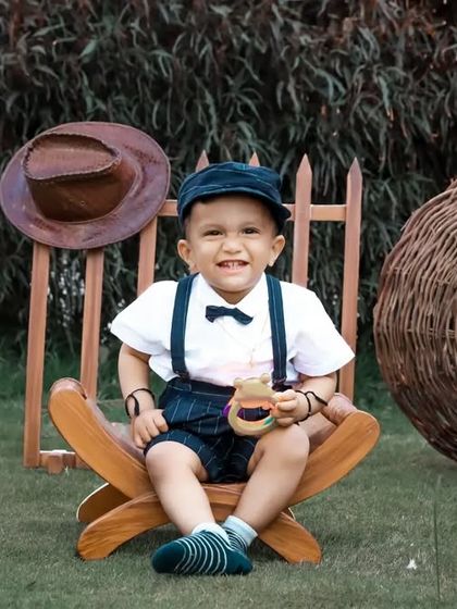 A happy toddler enjoying our vintage-themed outdoor setup, complete with a ukulele and other rustic props.