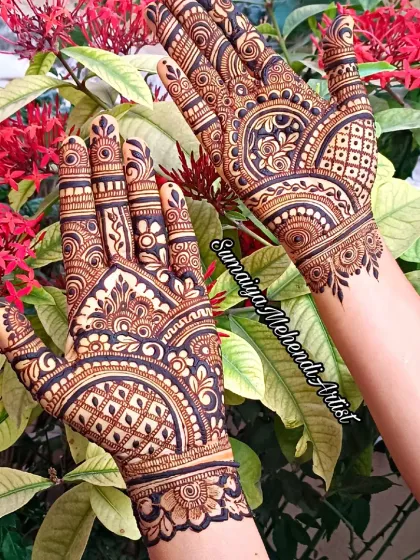 This design is all about symmetry and clean lines. It's a beautiful example of a modern party henna style that covers the back of the hands.
