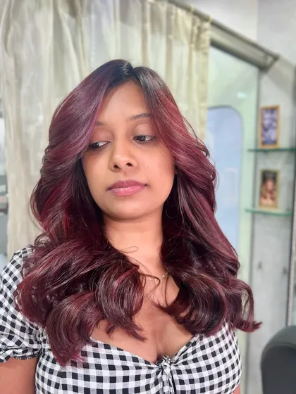 We love a bold colour choice. This vibrant red has hints of magenta and looks stunning with her complexion, styled with soft, face-framing waves.