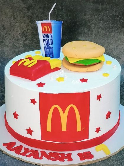 I'm lovin' it! A McDonald's themed cake made with whole wheat and fresh pineapple. It features a fondant burger, fries, and a drink for the ultimate fast-food fan.