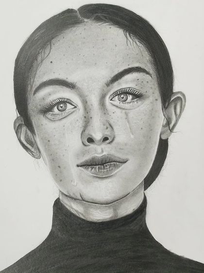 A stunning student portrait done with pencils, showcasing subtle shading to capture freckles and the emotion in the subject's eyes.