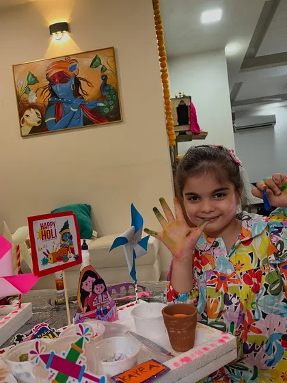 Showing off her colorful hands and her handmade Holi crafts, this student is ready for the festivities.