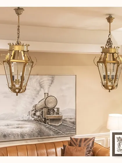 My vintage-style pendant lanterns add a touch of heritage and charm to this living space. The intricate brass frame and clear glass panels are ideal for creating focused, yet gentle, illumination over seating areas or in entryways.