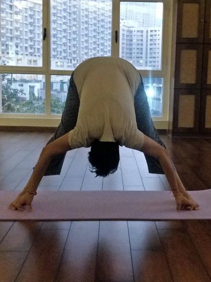 Another angle of Prasarita Padottanasana, showing how we can use our hands to deepen the forward fold.