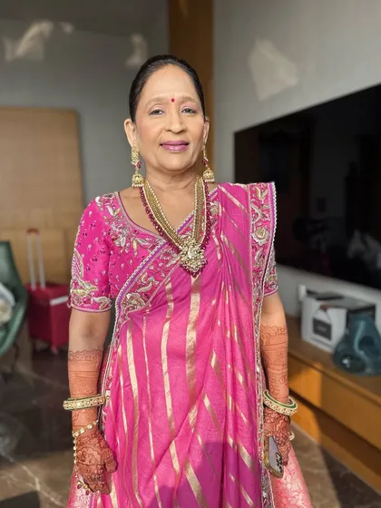 A beautiful, poised shot of the mother of the bride. The makeup is flawless and elegant, a perfect complement to her traditional attire and the joyous occasion.