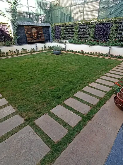 A look at a formal courtyard garden I designed, featuring a central lawn bordered by stone pavers. The space is enclosed by lush vertical gardens and a serene Buddha water feature, creating a private and symmetrical oasis.
