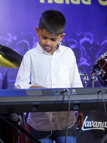 A young boy completely absorbed in playing his keyboard piece.