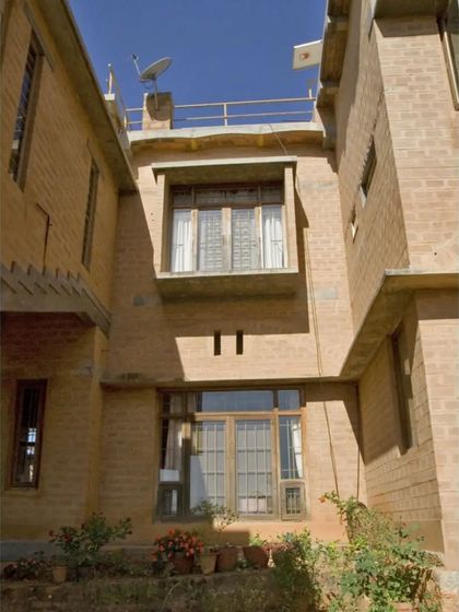 The facade of the Professor's Residence, showing how we use staggered windows and projecting bays to create architectural interest and control sunlight. The entire structure is built with compressed stabilised earth blocks.
