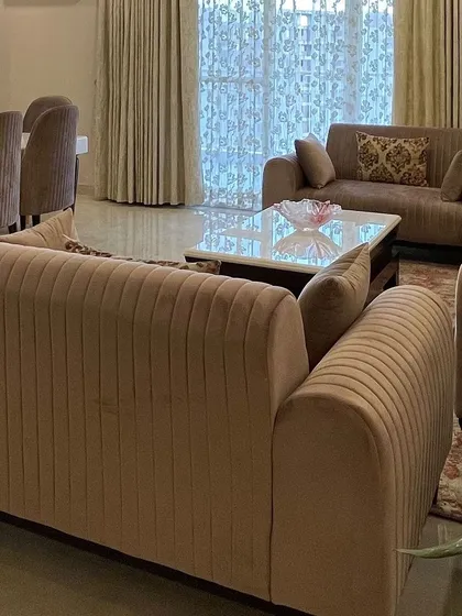 A view of the comfortable, channel-tufted sofas that define the living area. The design prioritizes both style and comfort for everyday living.