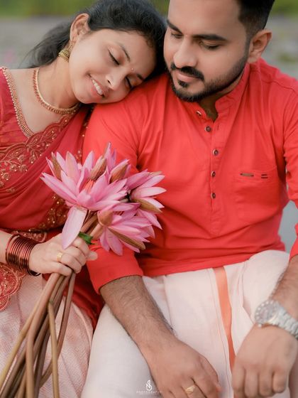 A detailed shot focusing on the couple's connection and the beautiful bouquet of water lilies. The traditional outfits add to the cultural richness of the image.