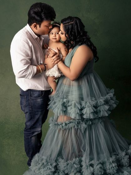 Kisses for the little one. This candid photo captures the parents showering their daughter with affection, creating a memory filled with warmth and love.