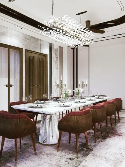 A dining room designed for abundance and connection. The spacious layout, luxurious marble table, and brilliant chandelier are not just aesthetic choices; they are Vastu elements intended to foster prosperity and harmonious family gatherings.