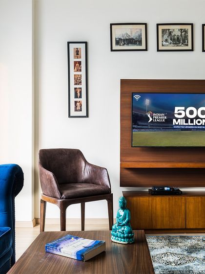 Cheering for my favourite team in style. This living room, with its bold blue velvet sofa and warm wood media console, is the perfect place to enjoy the IPL match in comfort.