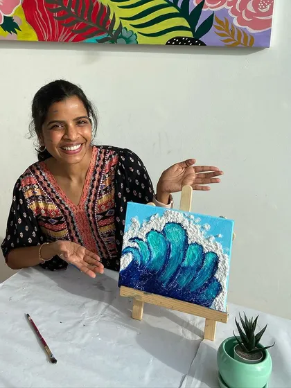 A participant proudly shows off her texture painting of a wave. The tactile nature of this art form is incredibly satisfying.