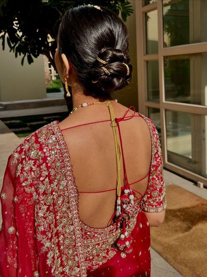 A look at the classic bridal bun. This hairstyle is not only elegant but also practical, keeping the focus on her beautiful backless blouse and jewelry.