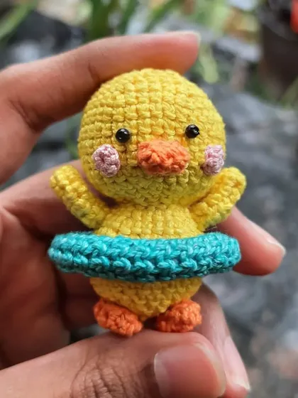 A close-up of the swimming duckling amigurumi. The tiny blush marks are hand-embroidered to give it an extra sweet look.