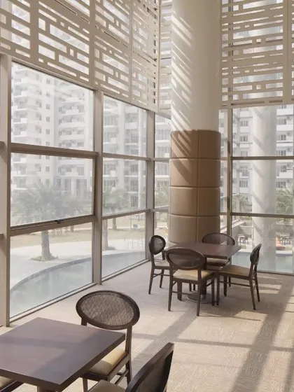 The MGF Palm Drive clubhouse in Gurugram features double-height glass walls and sun-shading screens. This design maximizes natural light and views, creating a strong connection to the surrounding landscape.