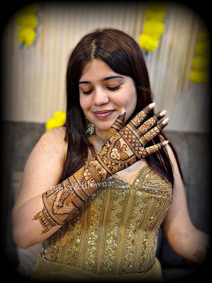 A bride admiring her beautiful mehndi. This shot highlights the intricate design on the back of her hand and arm.