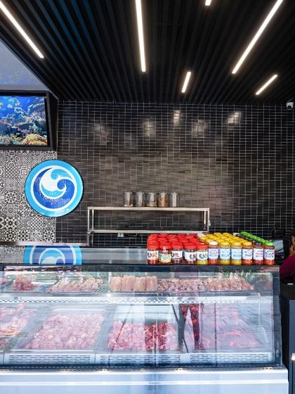 The meat display case is brightly lit to showcase product freshness. The layout provides ample space for staff to serve customers efficiently, even during peak hours.