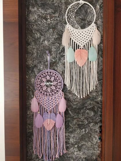 A pair of personalized macrame dreamcatchers. We can customize these with names and color palettes, like this lovely lavender and pastel pink combination for 'Keira'.