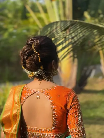 The side view of this traditional bun shows how it elegantly holds the hair away from the face, highlighting the bride's features and beautiful jewellery.