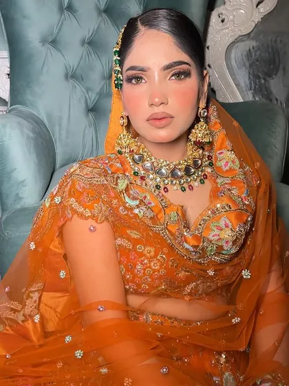 For the bride who loves a pop of color, this orange lehenga look is pure magic. The multi-colored Kundan jewelry complements the warm tones beautifully, creating a vibrant and memorable autumn bridal style.