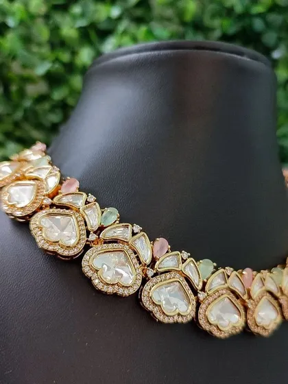 A beautiful pastel-toned necklace with large kundan stones and soft pink and green accents.