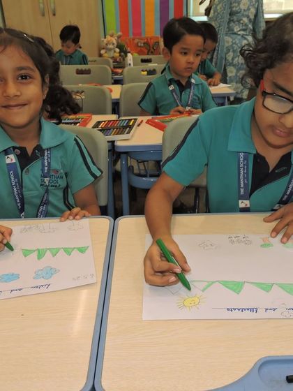 Two students work on their 'Listen and Illustrate' activity during Literacy Quest Week, translating words into pictures and enhancing their comprehension skills.