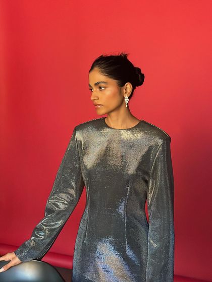The model posing against the red paper background. This BTS shot gives a sense of the studio environment and the lighting setup we used.